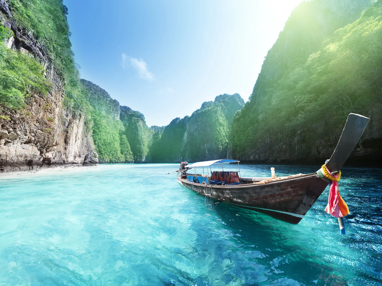 Longtail boat in a clear turquoise Phi Phi lagoon