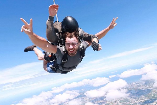 Tandem skydiver grinning in freefall high above the Pattaya coast