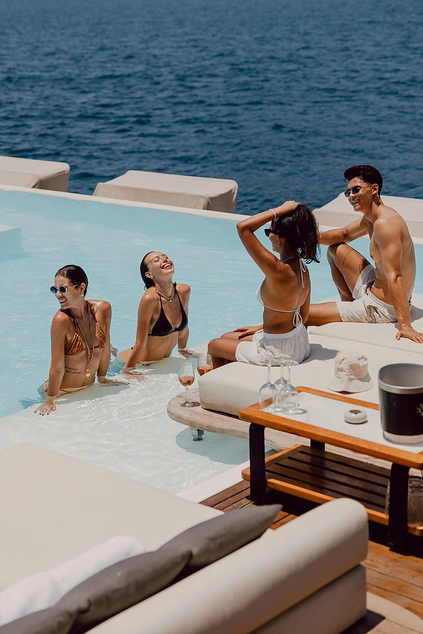 Friends relaxing at the infinity pool at YONA Beach Club with Andaman Sea views